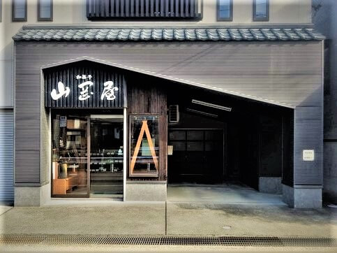 山岡屋村松店の外観写真です。村松町公民館の川向の家屋の一階部分となります。
